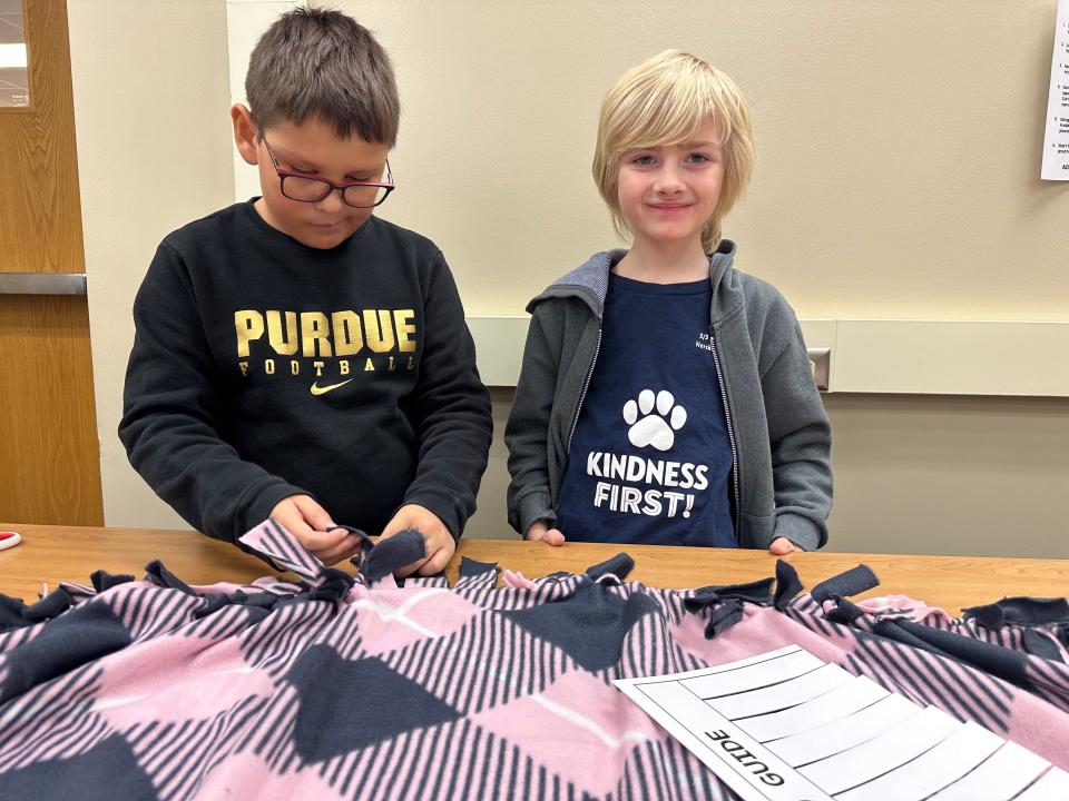 Alexander Schladetzky, left, and Wyatt Wiedenhoeft, right, work together to complete a section of their tie blanket as part of a kindness project at Hershey Elementary. The elementary school class plans to craft at least 25 blankets for donation to COVER Lafayette.