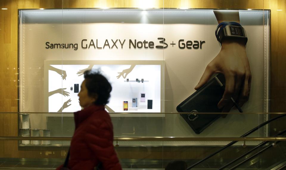 A woman walks by a billboard for Samsung Electronics' Galaxy Note 3 at a showroom of Samsung Electronics in Seoul, South Korea, Tuesday, Jan. 7, 2014. Samsung Electronics Co.'s fourth-quarter operating profit declined 6 percent over a year earlier, the company said Tuesday, underlining the challenges the world's largest smartphone maker faces as sales of mobile devices slow in advanced countries. (AP Photo/Lee Jin-man)