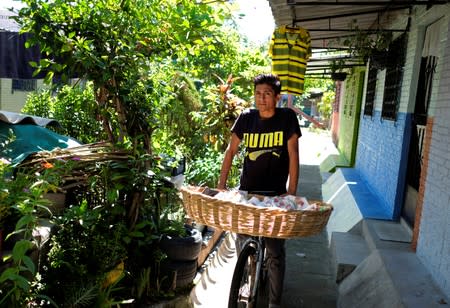 A vendor walks by the house of Rosa Ramirez in the Altavista neighbourhood in San Martin