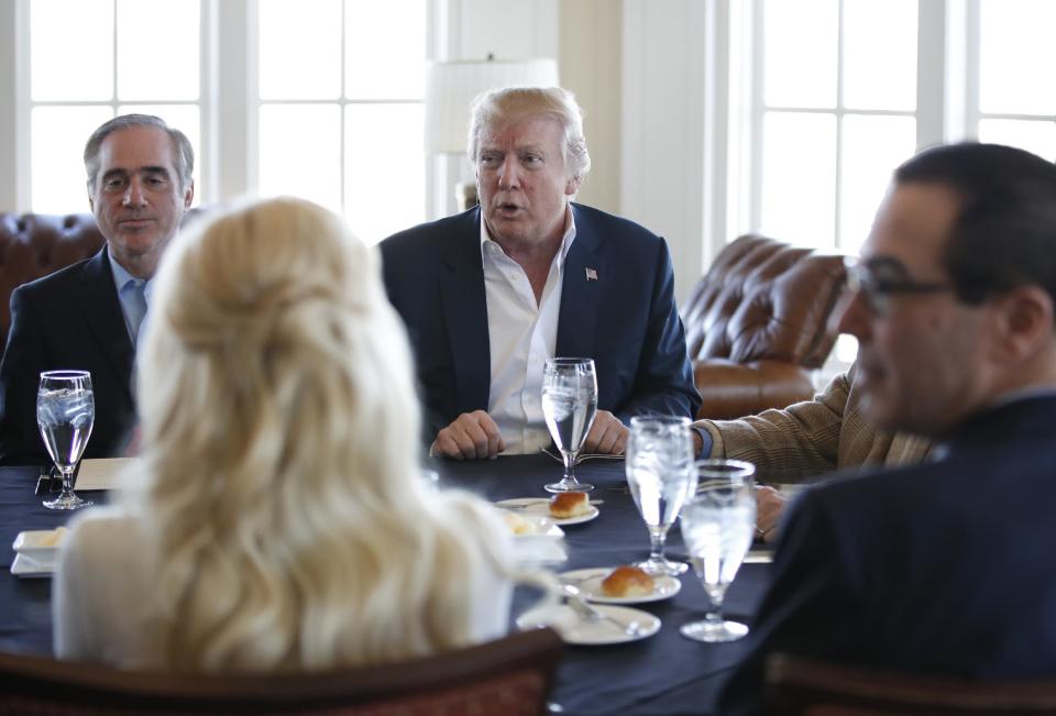 President Donald Trump, center, meets Treasury Secretary Steven Mnuchin, right, and Secretary of Veterans Affairs David Shulkin, left, along with other members of his cabinet and the White House staff, Saturday, March 11, 2017, at the Trump National Golf Club in Sterling, Va. (AP Photo/Manuel Balce Ceneta)