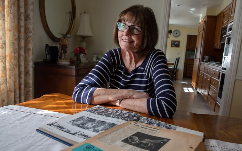 Joanne Hess Mittmann, a member of the Anaheim High School Ana-Hi-Steppers in 1967, shows her scrapbook.