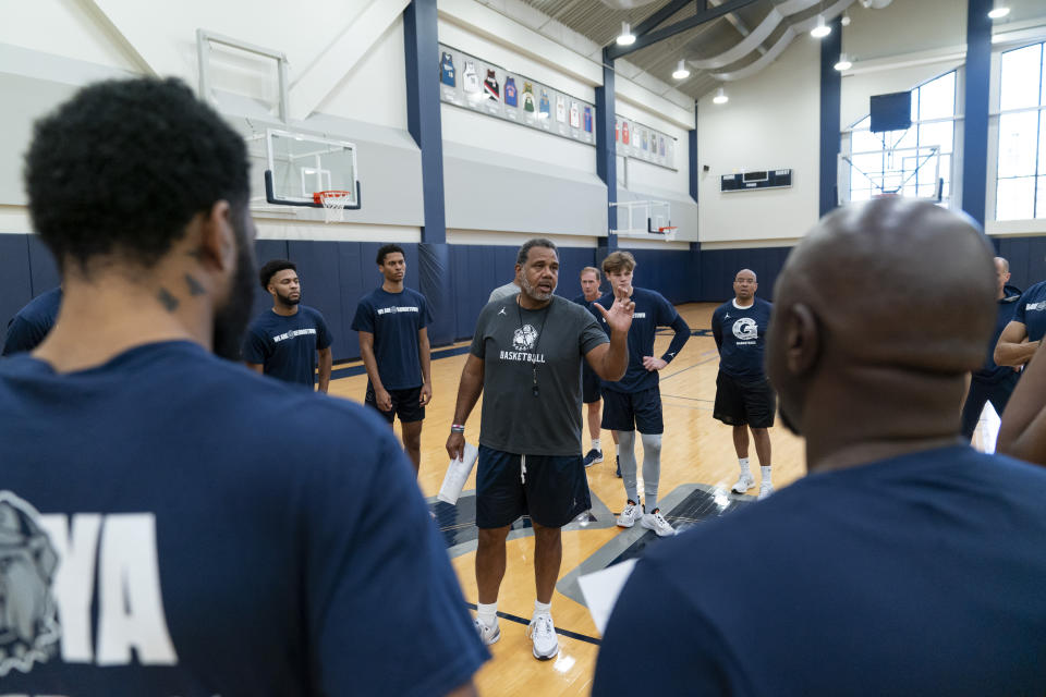 Georgetown head coach Ed Cooley, center, speaks to players before the start of an NCAA college basketball practice Thursday, Oct. 19, 2023, in Washington. (AP Photo/Stephanie Scarbrough)