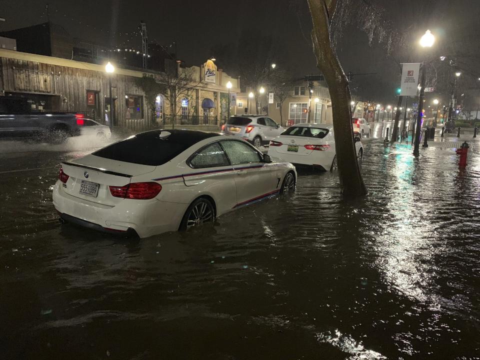 In this photo released by Adam Fowler, vehicles sit parked in on the side of a main road in floodwater, Wednesday, Feb. 6, 2020, in Tuscaloosa, Alabama. (Adam Fowler via AP)