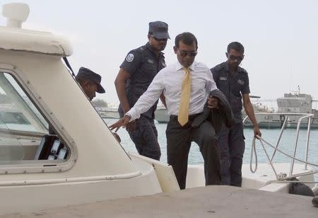 Former Maldives' President Mohamed Nasheed arrives at Mal'e City with police officers, for the first hearing of the trial held at Criminal Court in Male, February 23, 2015. REUTERS/Waheed Mohamed/Files