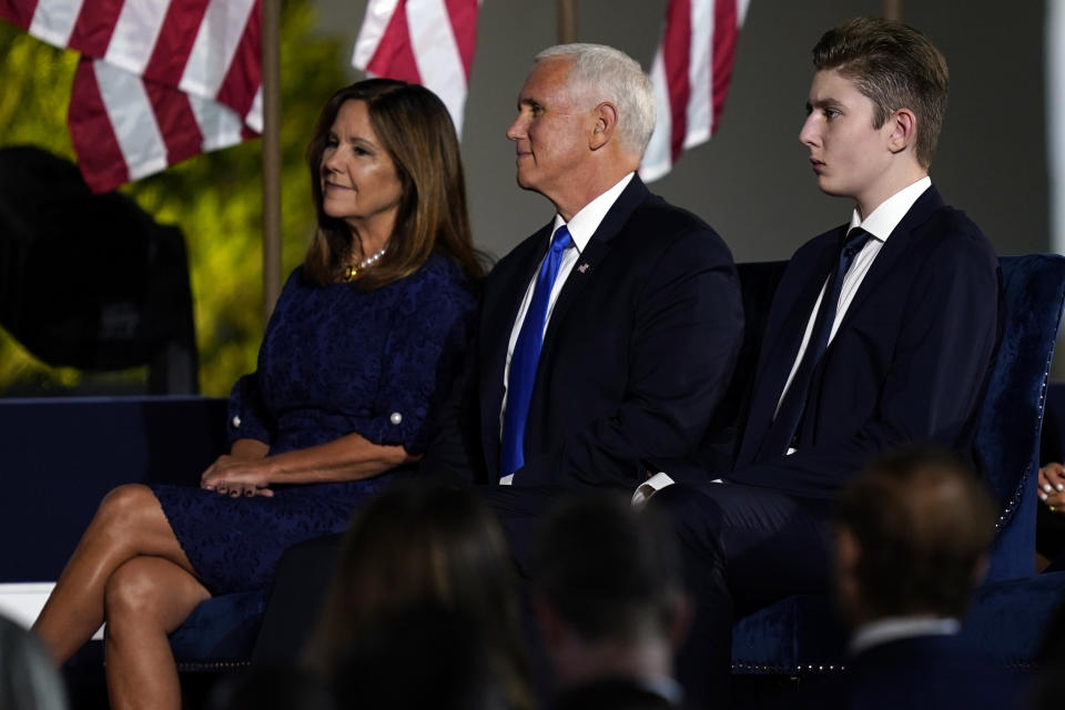Barron Trump sits next to Vice President Mike Pence and Karen Pence as they wait for President Donald Trump to speak from the South Lawn of the White House on the fourth day of the Republican National Convention, Thursday, Aug. 27, 2020, in Washington. (AP Photo/Evan Vucci)