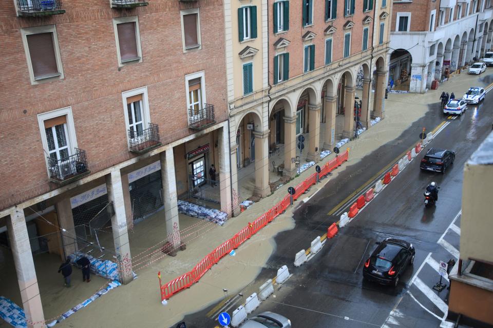 Sandbags are lined up along a flooded street in Bologna, Italy, Tuesday, May 16, 2023.