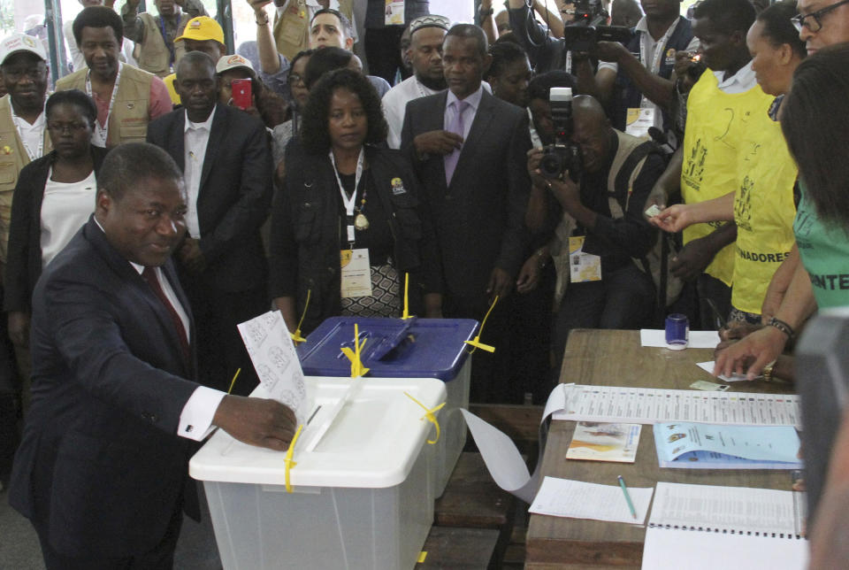 Mozambican President Felipe Nyusi, bottom left, casts his vote in Maputo, Tuesday, Oct. 15, 2019 in the country's presidential, parliamentary and provincial elections. Polling stations opened across the country with 13 million voters registered to cast ballots in elections seen as key to consolidating peace in the southern African nation. (AP Photo/Ferhat Momade)