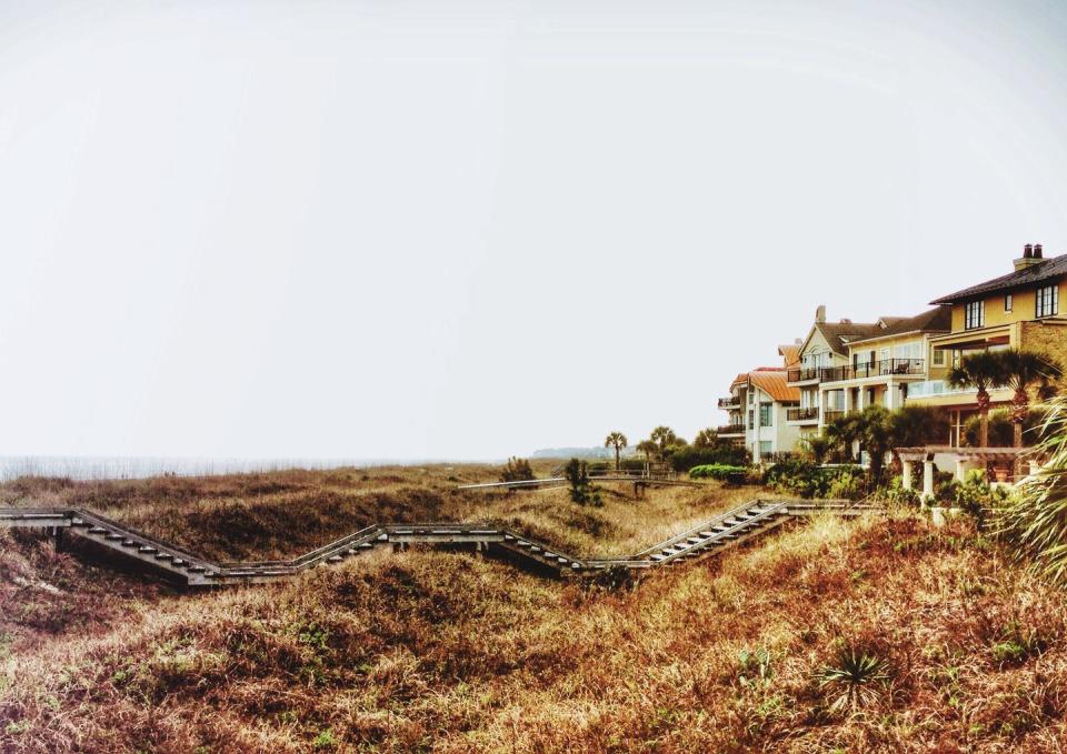 scenic view of houses surrounded by grassy field