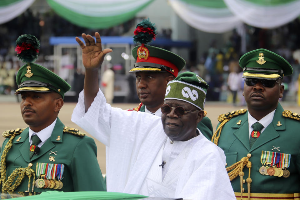 FILE - Nigeria's new President Bola Ahmed Tinubu, center, inspects honour guards after taking an oath of office at a ceremony in Abuja, Nigeria, on May 29, 2023. Nigeria's president has signed on Wednesday Nov. 8, 2023 a controversial bill that earmarks $6.1 million for a presidential yacht and millions more for sport utility vehicles for his wife and other top government officials. (AP Photo/Olamikan Gbemiga, File)