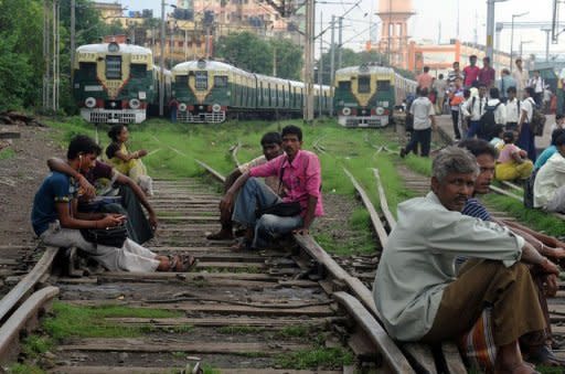 Indian passengers sit on the railway tracks near the platform of Sealdah train station waiting for the resumption of services during a power failure in Kolkata on July 31. India restored its power supplies on Wednesday after two days of massive outages that blacked out half the country, but fears remained that the grid could collapse again under the strain of over-demand