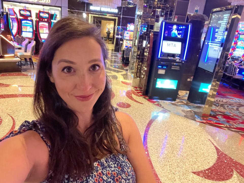 A woman takes a selfie in front of slot machines.