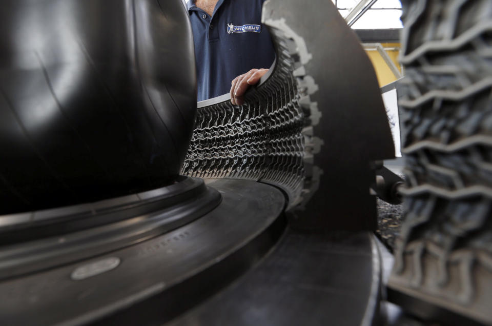 An employee works on a car tyre at the Michelin tyre company's factory in Clermont-Ferrand, central France, July 10, 2013. French tyremaker Michelin announced 700 domestic job cuts on June 2013, becoming the latest autos industry manufacturer to slash staffing in response to the European downturn. The world's second-largest tyremaker also unveiled 800 million euros ($1.1 billion) in planned investments to improve competitiveness and boost exports from its home country.  Picture taken July 10, 2013.  REUTERS/Regis Duvignau (FRANCE - Tags: BUSINESS TRANSPORT)