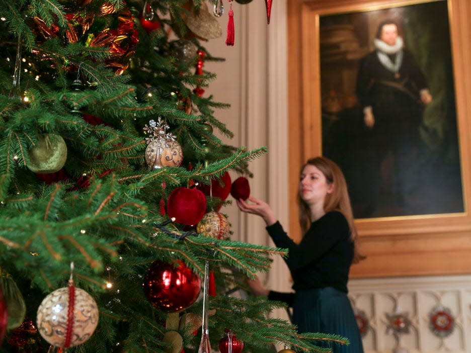 A Royal Collection Trust member decorates the Christmas tree.