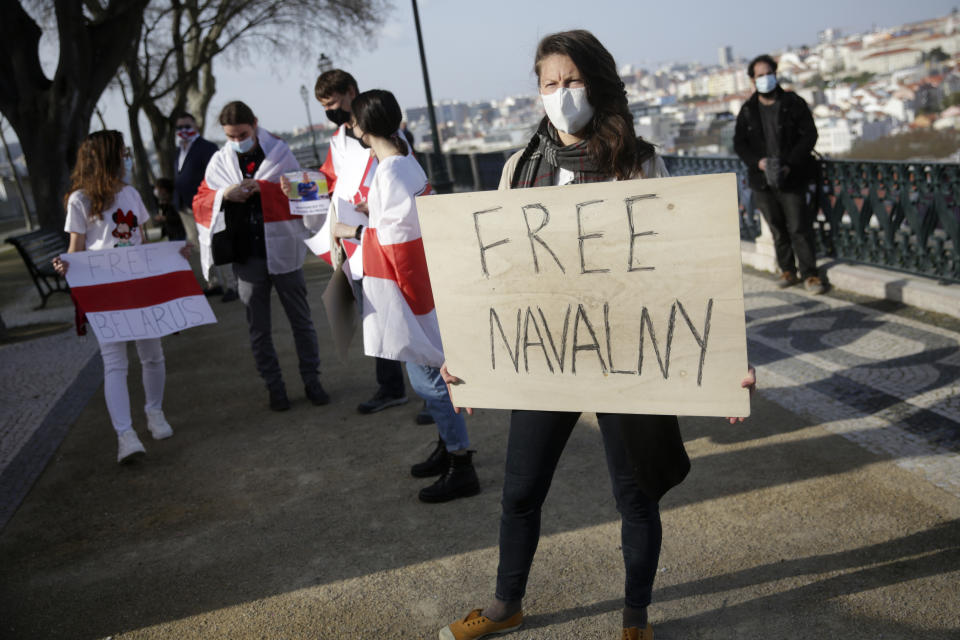 Ksenia Ashrafullina holds a poster during a protest demanding freedom for political prisoners organized by a Belorussian cultural association, in Lisbon, March 6, 2021. The mayor of Lisbon is under fire after admitting that municipal employees shared with Russian officials personal details of Ashrafullina and at least two other Lisbon-based dissidents who organized protests in support of Russian jailed opposition leader Alexei Navalny. (AP Photo/Armando Franca)