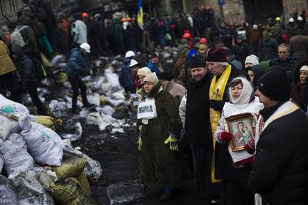 People sing religious songs at the barricades of an anti-government protesters camp near in Kiev, January 28, 2014. REUTERS/Thomas Peter