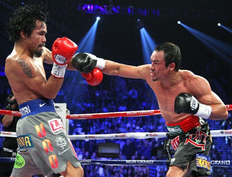 Manny Pacquiao (L) and Juan Manuel Marquez battle during their welterweight fight at the MGM Grand Garden in Las Vegas, Nevada. Marquez knocked out Pacquiao in the 6th round. Pacquiao says he welcomes another fight with Marquez, one that would put them into an elite class of boxing champions who have met five times in the ring