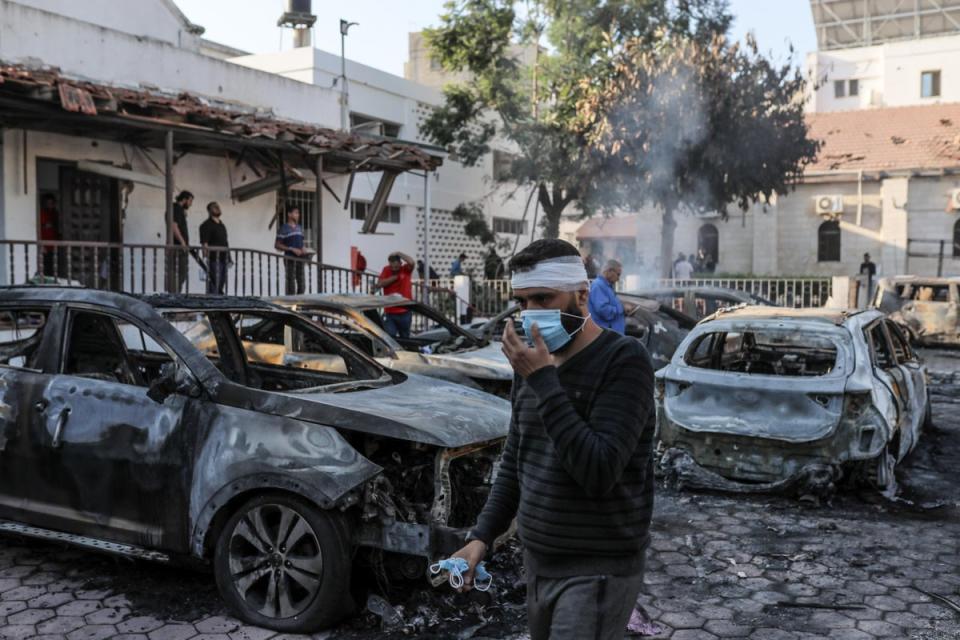 Wrecked vehicles smoulder after al-Ahli Baptist Hospital was hit in Gaza City (Anadolu/Getty)