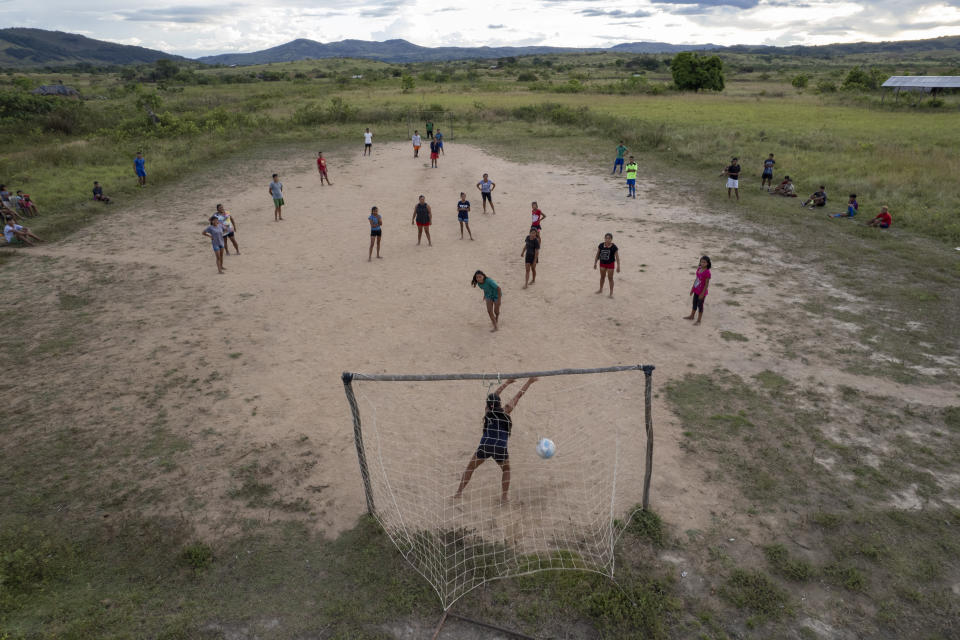 Indigenous from the Macuxi ethnic group play soccer in the Maturuca community on the Raposa Serra do Sol Indigenous reserve where mining is illegal in Roraima state, Brazil, Saturday, Nov. 6, 2021. President Jair Bolsonaro publicly opposed Raposa Serra do Sol's demarcation in 2005 and often holds it up as an example of a large swath of land ripe for productive activities. (AP Photo/Andre Penner)