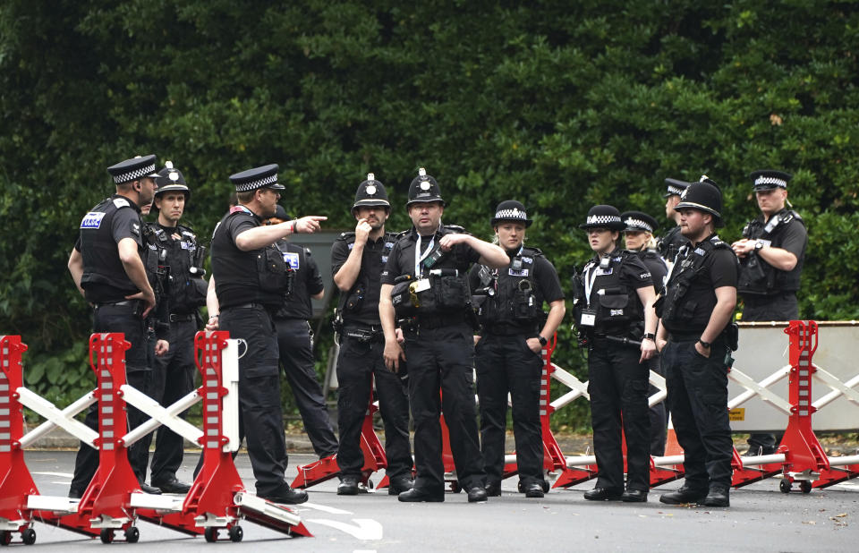 FILE - In this Thursday, June 10, 2021 file photo, police gather to patrol a checkpoint in St. Ives, Cornwall, England. Towering steel fences and masses of police have transformed the Cornish seaside as leaders of the Group of Seven wealthy democracies descent for a summit near St. Ives in Cornwall, a popular holiday destination. A huge frigate dominates the coastline, armed soldiers guard the main sites and some 5,000 extra police officers have been deployed to the area. (AP Photo/Jon Super, File)