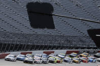 Cars approach the starting line in front of empty stands to start the NASCAR Cup Series auto race Sunday, May 17, 2020, in Darlington, S.C. (AP Photo/Brynn Anderson)