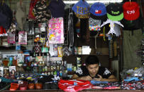 In this April 10, 2019, photo, a shopkeeper waits for business in Nuku'alofa, Tonga. China is pouring billions of dollars in aid and low-interest loans into the South Pacific, and even in the far-flung kingdom of Tonga there are signs that a battle for power and influence among much larger nations is heating up and could exact a toll. (AP Photo/Mark Baker)