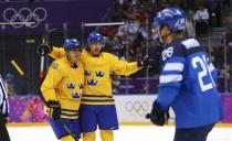 Sweden's Erik Karlsson celebrates his goal against Finland with teammate Alexander Steen (L) as Finland's Jarkko Immonen (R) skates by during the second period of the men's ice hockey semi-final game at the Sochi 2014 Winter Olympic Games, February 21, 2014. REUTERS/Mark Blinch