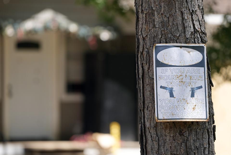 A warning sign is seen Sunday, April 30, 2023, outside the home where a mass shooting occurred Friday night, in Cleveland, Texas. The search for a man who allegedly shot his neighbors after they asked him to stop firing off rounds in his yard stretched into a second day Sunday, with authorities saying the man could be anywhere by now. Francisco Oropeza, 38, fled after the shooting Friday night that left several people dead, including a young boy. (AP Photo/David J. Phillip)