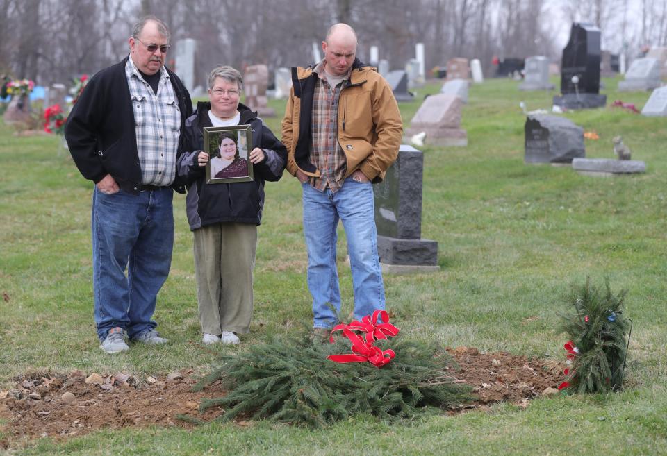 Frank and Jody Malinowski, left, stand with their son, Frank "Keith" Malinowski, at the grave of Jamie Malinowski at Chestnut Hill Cemetery in Doylestown. Jamie died at age 34 of COVID-19.