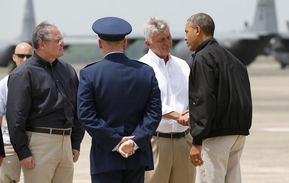 U.S. President Barack Obama is greeted by Arkansas Governor Mike Beebe (2nd R) and U.S. Senator Mark Pryor (L) upon his arrival in Little Rock, Arkansas May 7, 2014. Obama is in Arkansas to see the damage cause by recent tornadoes and meet with families and first responders. The tornadoes were part of a storm system that blew through the Southern and Midwestern United States earlier this week, killing at least 35 people, including 15 in Arkansas. Obama has already declared a major disaster in Arkansas and ordered federal aid to supplement state and local recovery efforts. (REUTERS/Kevin Lamarque)