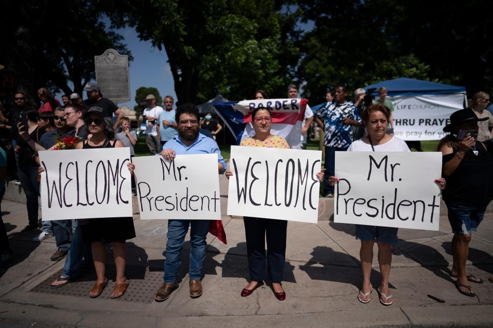 People hold up signs welcoming President Joe Biden and first lady Jill Biden who were about to drive past them at a memorial site in the town square of Uvalde set up for those killed in the mass shooting (AP)