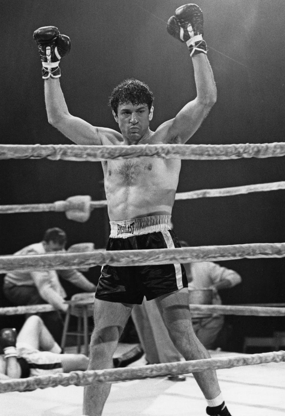 Robert De Niro in a boxing ring with his hands raised