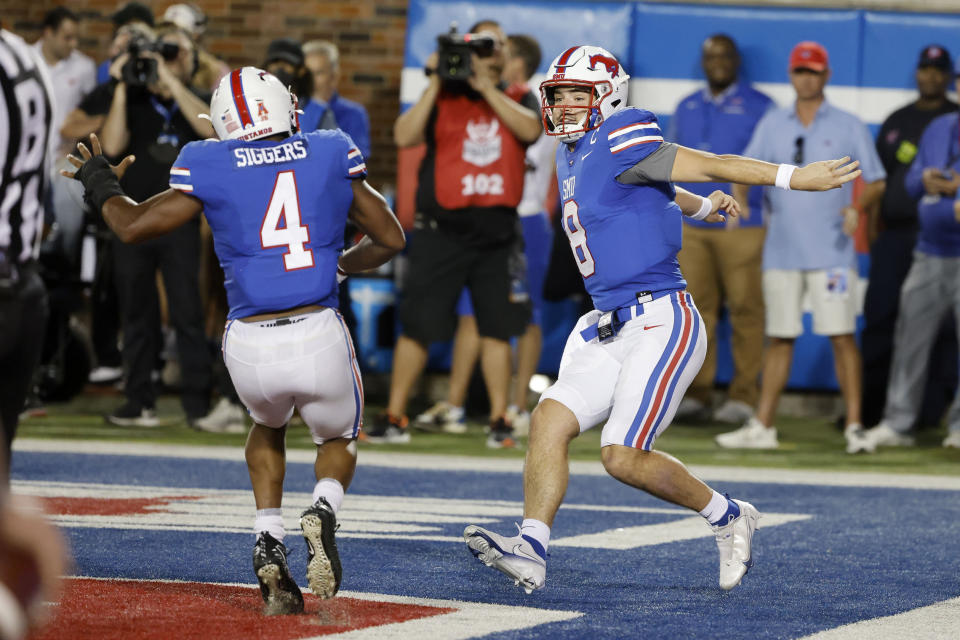 SMU running back Tre Siggers (4) celebrates with quarterback Tanner Mordecai (8) after Mordecai scored a rushing touchdown against Tulane during the first half of an NCAA college football game in Dallas, Thursday, Oct. 21, 2021. (AP Photo/Michael Ainsworth)