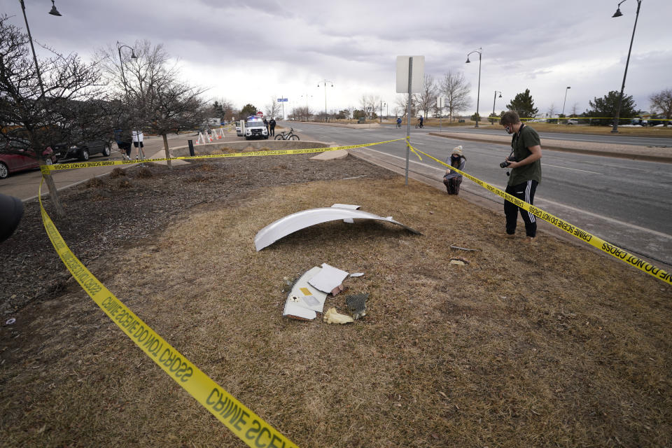 People look over debris that fell off a plane that shed parts over a neighborhood in Broomfield, Colo., Saturday, Feb. 20, 2021. The plane was making an emergency landing at nearby Denver International Airport. (AP Photo/David Zalubowski)