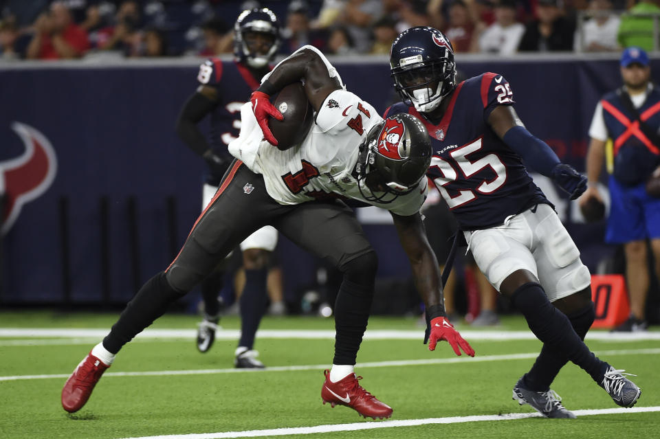 Tampa Bay Buccaneers' Chris Godwin (14) reaches for the end zone to score a touchdown after catching a pass as Houston Texans defensive back Desmond King II (25) defends during the first half of an NFL preseason football game Saturday, Aug. 28, 2021, in Houston. (AP Photo/Eric Christian Smith)