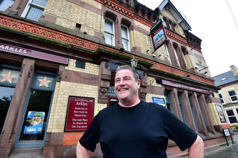 Paul Tremarco, manager, dressed in a black shirt, stands outside of The Arkles pub in Anfield