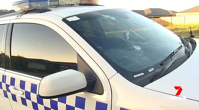 Vehicles, including a police car, parked in the street were extensively damaged. Source: 7 News