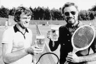 Was macht ein Hollywood-Star wie Charlton Heston (rechts) 1976, wenn er einen neuen Film bewirbt? Richtig: Er besucht Torwart-Legende Sepp Maier auf dem Tennisplatz und beide stoßen mit einem Bier an. (Bild: Bettmann / Getty Images)