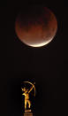 <p>The eclipsing blood moon appears above the statue of Kansa Warrior Ad Astra atop the Kansas Statehouse in Topeka, Kan., Wednesday, Jan. 31, 2018. (Photo: Orlin Wagner/AP) </p>