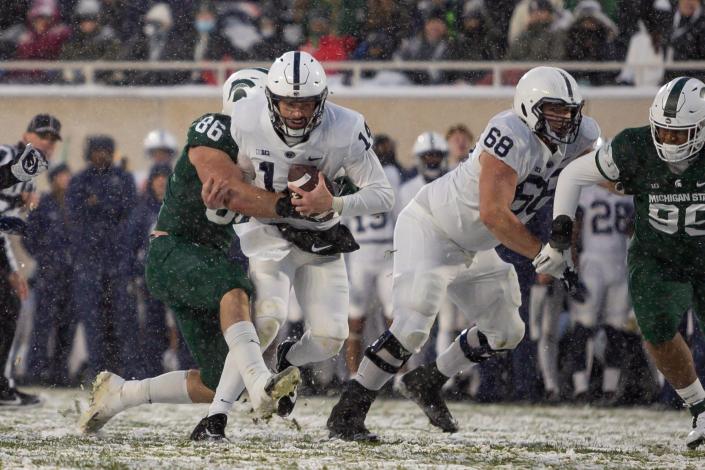 Nov 27, 2021; East Lansing, Michigan, USA; Penn State Nittany Lions quarterback Sean Clifford (14) gets wrapped up by Michigan State Spartans defensive end Drew Beesley (86) during the second quarter at Spartan Stadium. Mandatory Credit: Raj Mehta-USA TODAY Sports