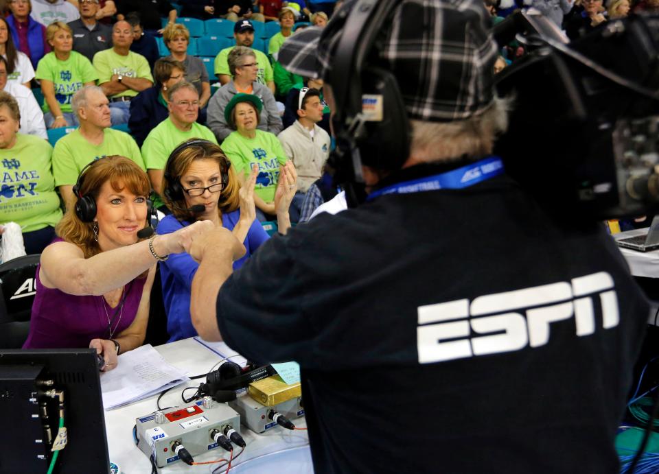 In this Sunday, March 5, 2017 photo, Debbie Antonelli, left, a women's college basketball analyst for ESPN, fist bumps a cameraman before the start of the women's basketball game between Duke and Notre Dame at the NCAA college basketball game in the championship of the Atlantic Coast Conference tournament at the HTC Center in Conway, S.C. Antonelli will be first woman to broadcast men’s NCAA Tournament games in over two decades. She’s no stranger to the men’s game or its fans, doing ACC games for the past six years. (AP Photo/Mic Smith)