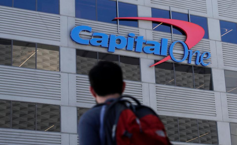 In this July 16, 2019, photo, a man walks across the street from a Capital One location in San Francisco.