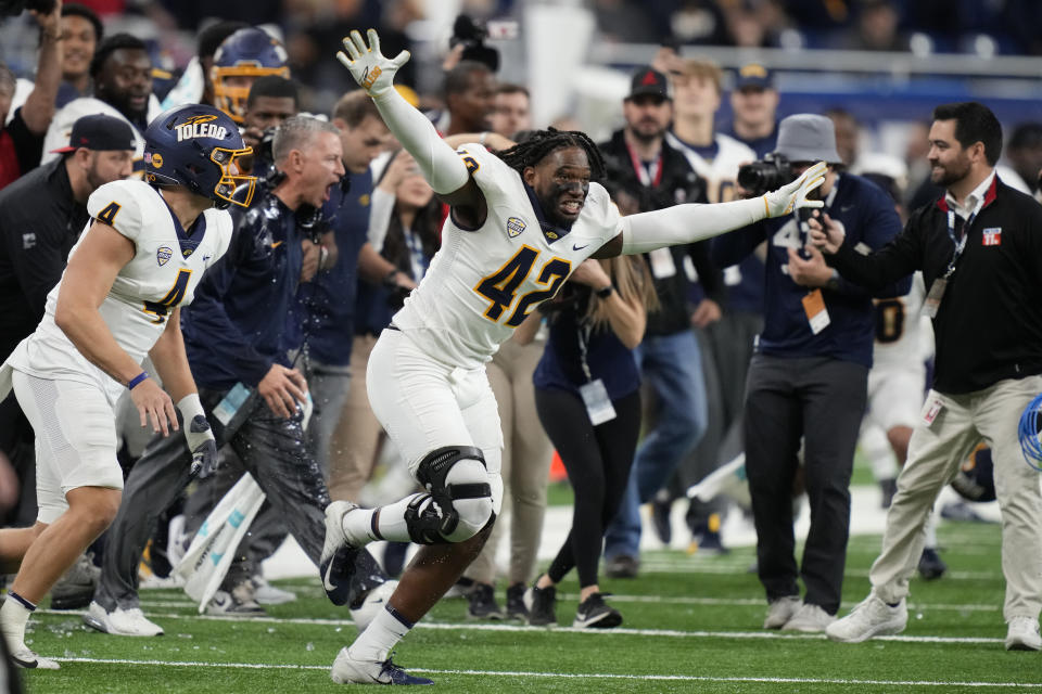 Toledo linebacker Jackson Barrow (42) and team run onto the field after the Mid-American Conference championship NCAA college football game against Ohio, Saturday, Dec. 3, 2022, in Detroit. (AP Photo/Carlos Osorio)