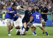 Scotland's Finn Russell passes the ball as he runs at the Samoan defence during the Rugby World Cup Pool A game at Kobe Misaki Stadium between Scotland and Samoa in Kobe City, Japan, Monday, Sept. 30, 2019. (AP Photo/Aaron Favila)
