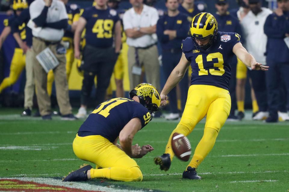 Michigan punter Brad Robbins holds the ball for *Michigan place kicker Jake Moody (13) as he makes a field goal in the second quarter of the Fiesta Bowl on Saturday, Dec. 31 at State Farm Stadium in Glendale, Ariz.