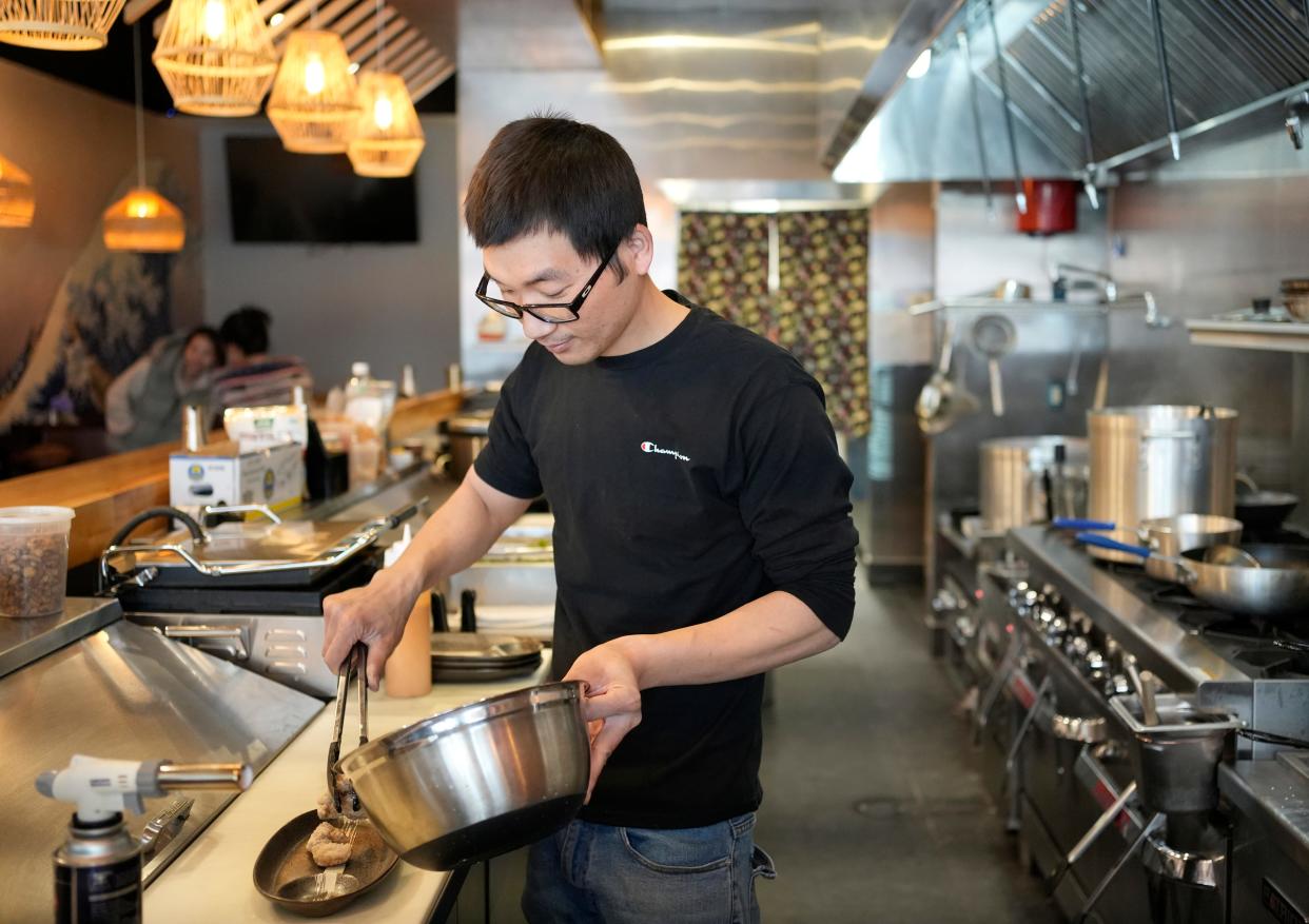 Leon Zhu, a trained ramen chef, serves a fried chicken appetizer at Kyushu Ramen on West Fifth Avenue.