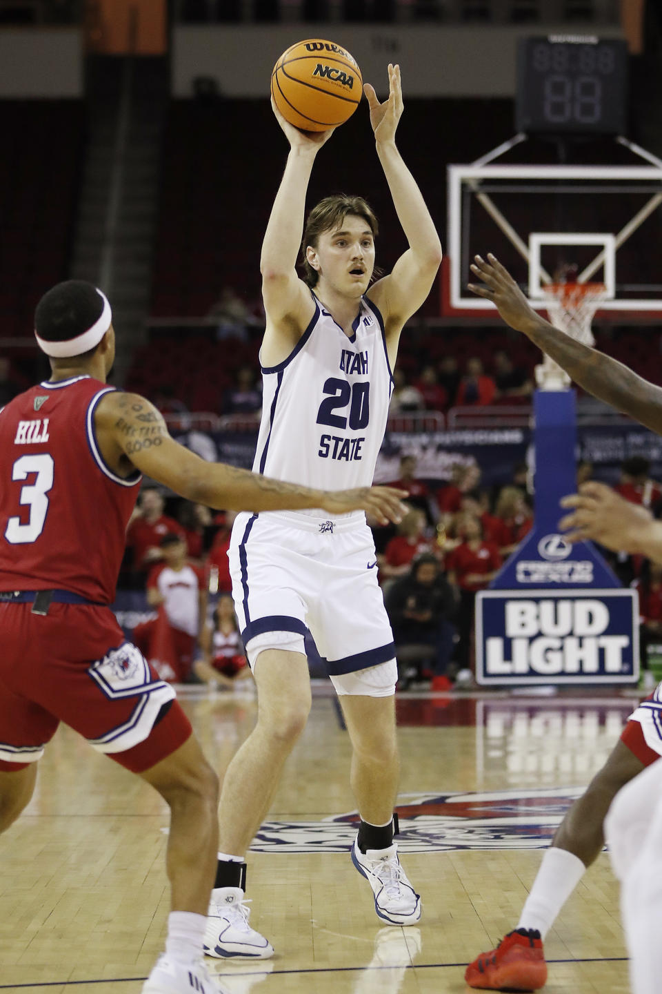 Utah State's Isaac Johnson passes off against Fresno State's Isaiah Hill during the first half of an NCAA college basketball game in Fresno, Calif., Tuesday, Feb. 27, 2024. (AP Photo/Gary Kazanjian)