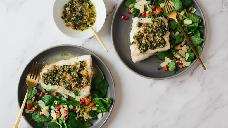 White fish with buttery herb topping and salad