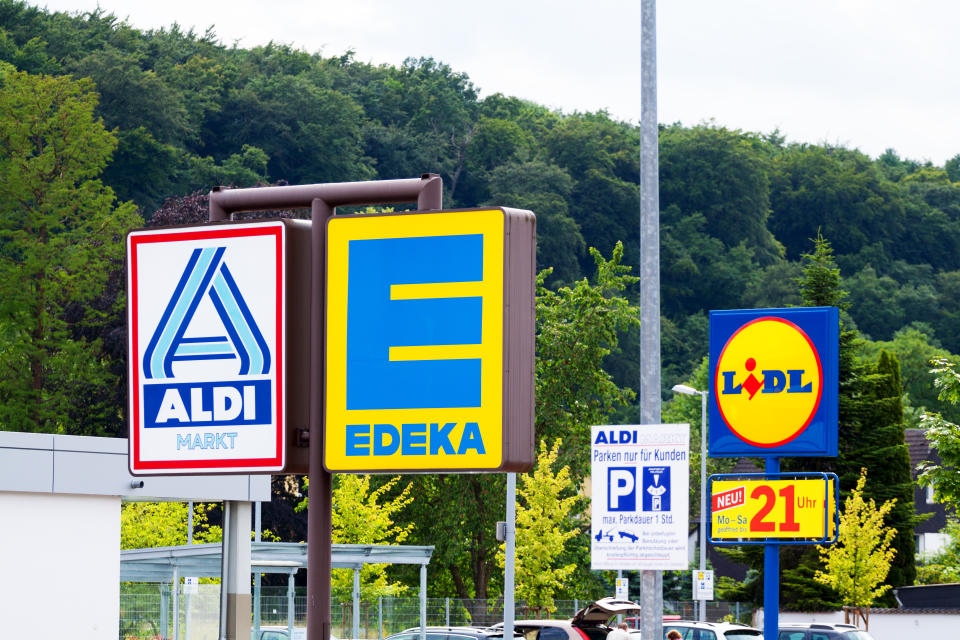 Essen, Germany - June 21, 2014: Capture of logos and signs of three German big discounters close together, seen from shared parking space in Essen Kettwig. There are logos of Aldi North, Edeka and Lidl.