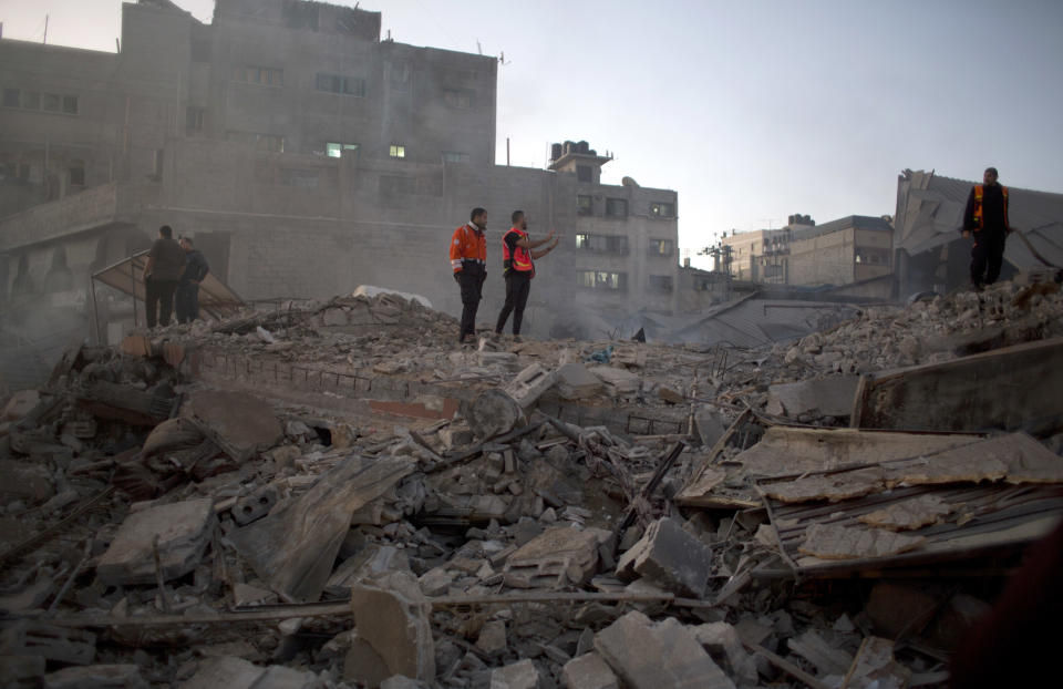 Palestinian firefighters check the dame of destroyed buildings hit by Israeli airstrikes early morning in Gaza City, Saturday, Oct. 27, 2018. Israeli aircraft have struck dozens of militant sites across the Gaza Strip as militants fired some 30 rockets into Israel. (AP Photo/Khalil Hamra)