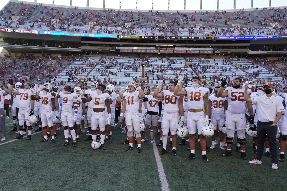 FILE - In this Saturday, Oct. 24, 2020, file photo, Texas players, including Sam Ehlinger (11), sing "The Eyes Of Texas" after an NCAA college football game against Baylor in Austin, Texas. The University of Texas' long-awaited report on the history of the school song “The Eyes of Texas” found it had “no racist intent,” but the school will not require athletes and band members to participate in singing or playing it at games and campus events. The song had erupted in controversy in 2020 after some members of the football team demanded the school stop playing it because of racist elements in the song’s past. (AP Photo/Chuck Burton, File)
